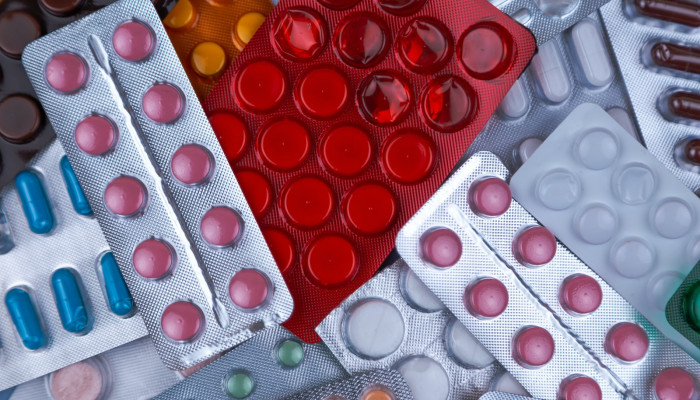 pile of blister packs of colorful medicine tablets