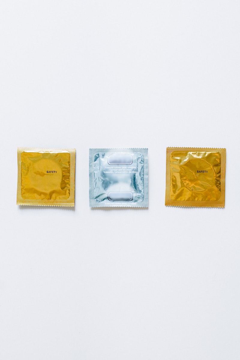 Three Condoms on White Surface